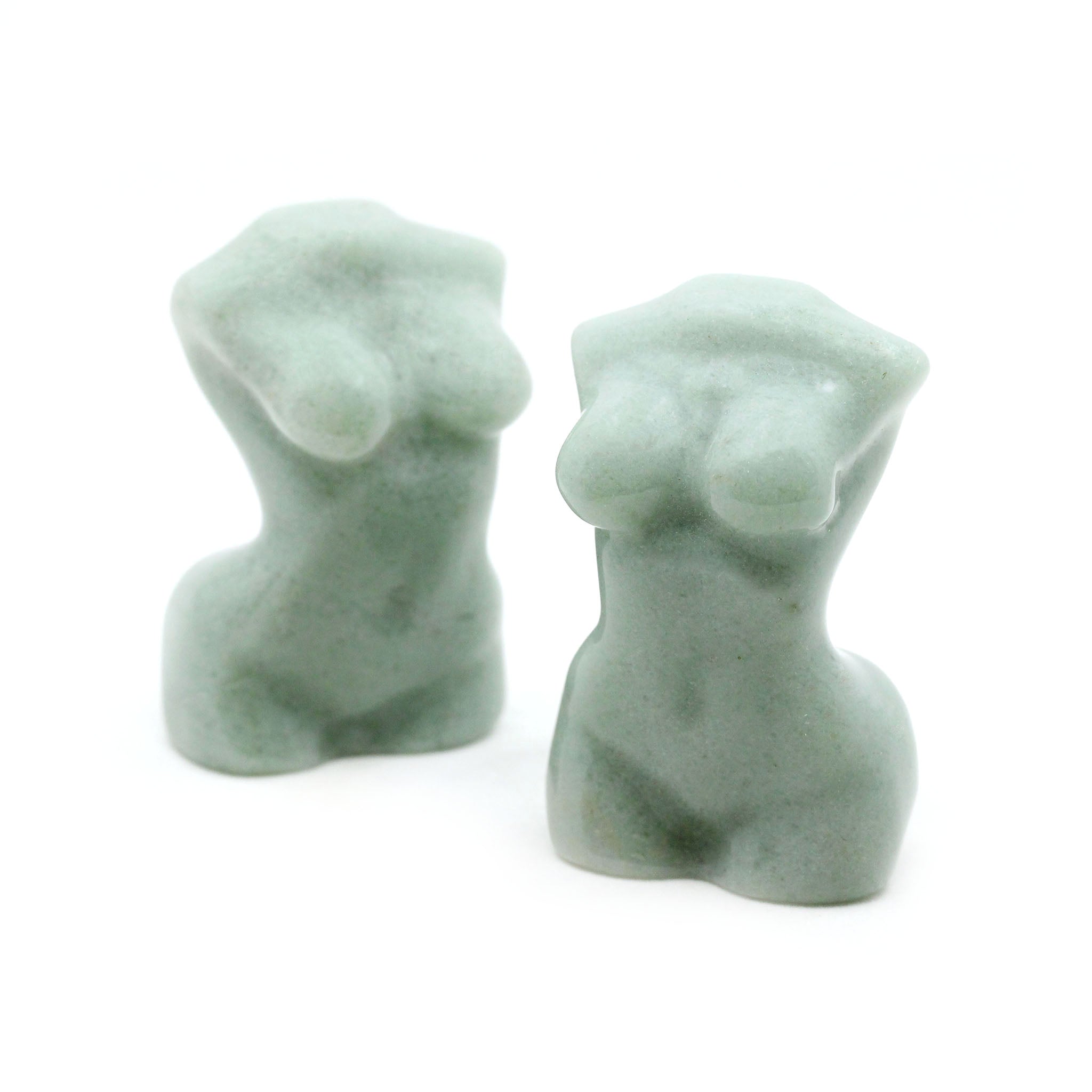 Two sculptures in the shape of female bodies from neck down to upper thigh, with no arms, made from green aventurine on a white background