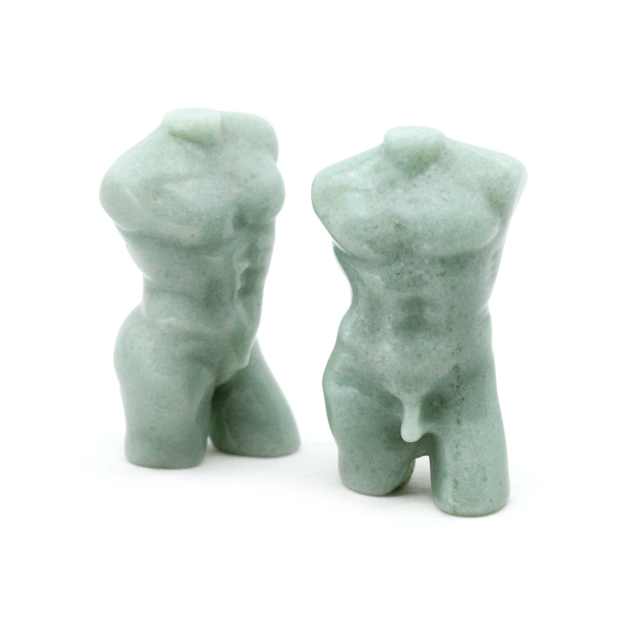 Two sculptures in the shape of male bodies from neck down to upper thigh, with no arms, made from green aventurine, on a white background