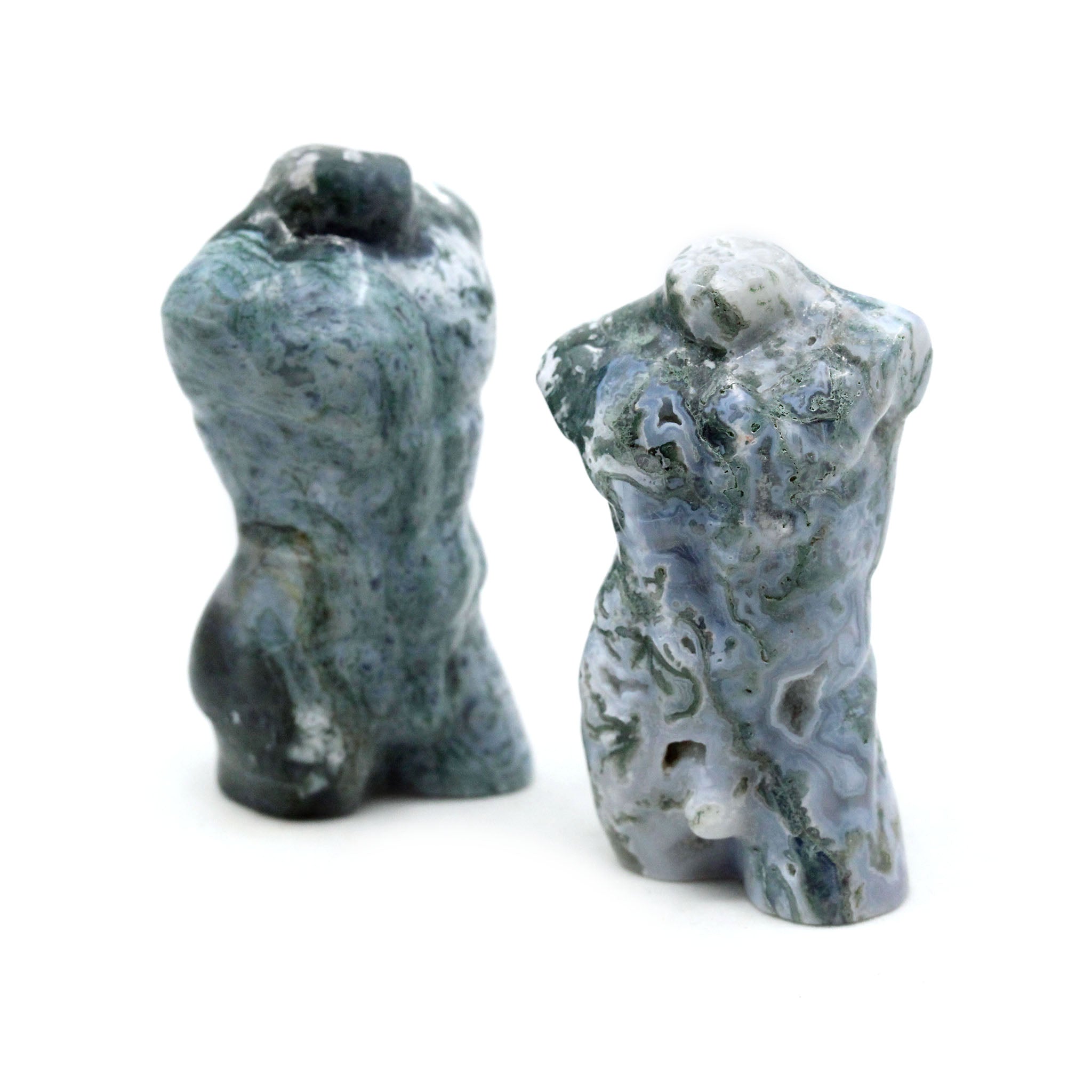 Two sculptures in the shape of male bodies from neck down to upper thigh, with no arms, made from moss agate, on a white background