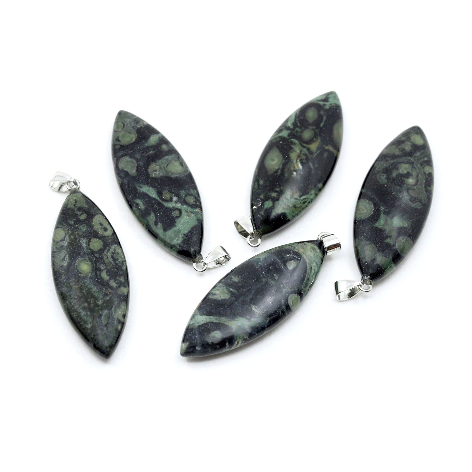 Five surfboard shaped pendants made from Kambaba Jasper with on a white background. Kambaba Jasper is dark green and black with orb-like formations that resemble fossilized algae or crocodile eyes.