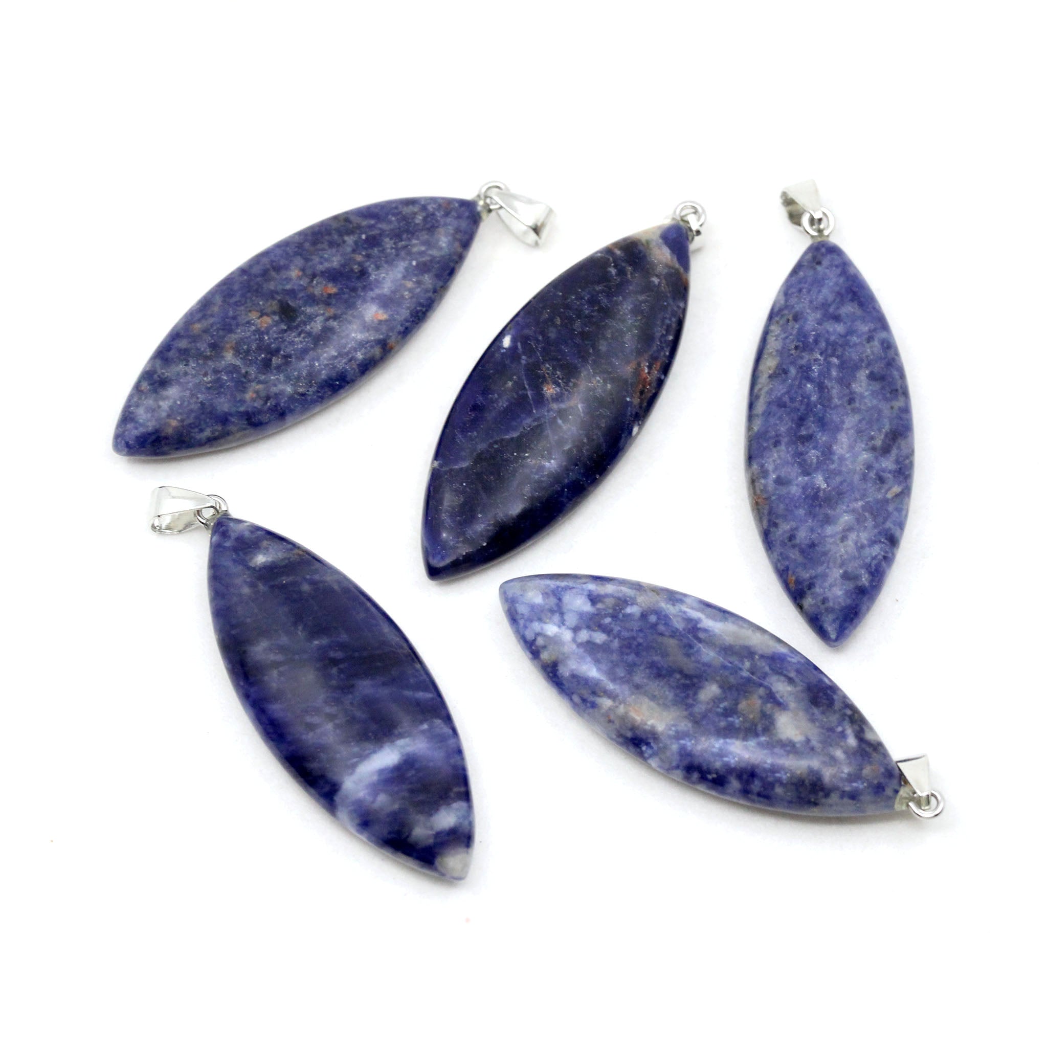 Five surfboard shaped pendants made from blue Sodalite on a white background