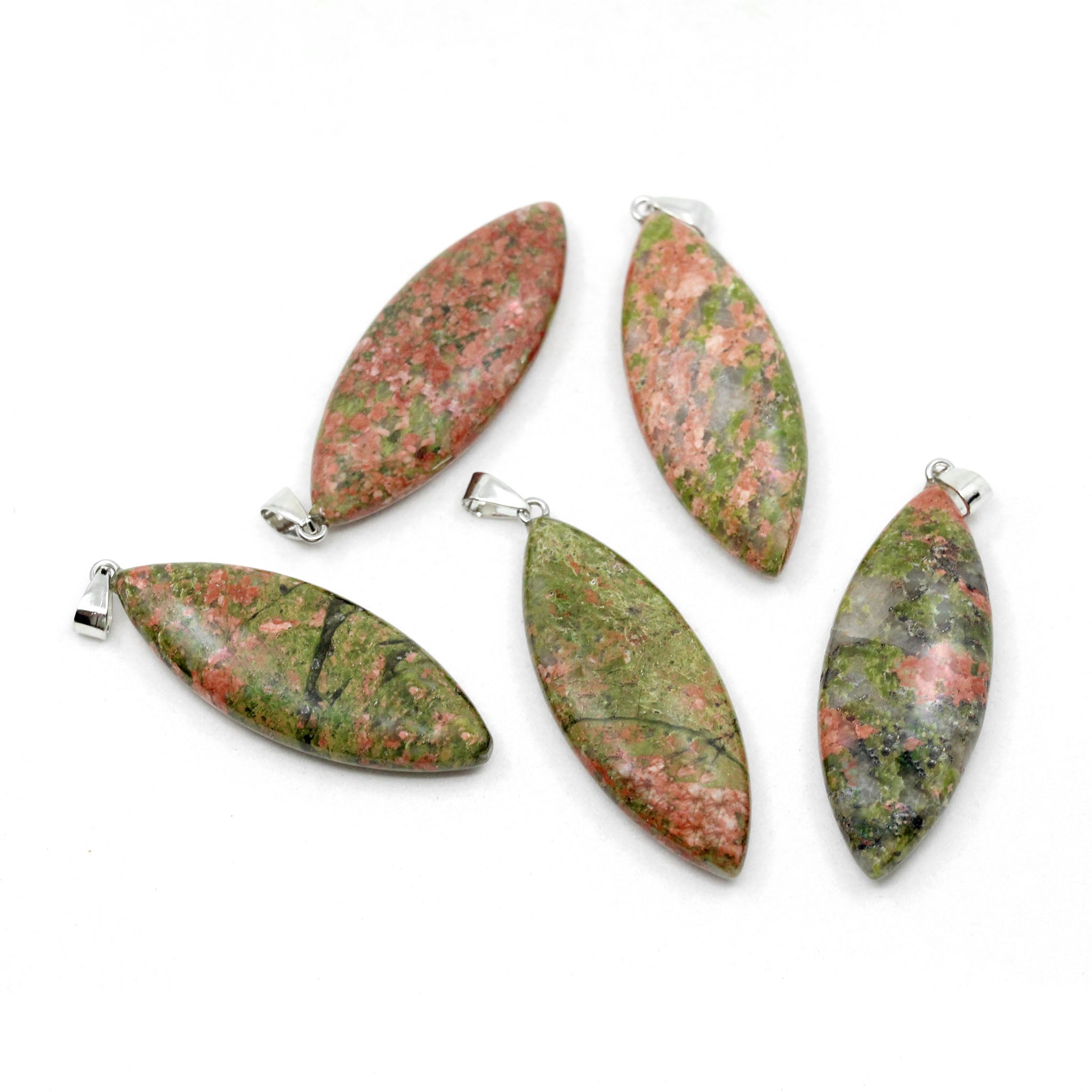 Five surfboard shaped pendants made from Unakite on a white background. Unakite is orange pink and green in color.