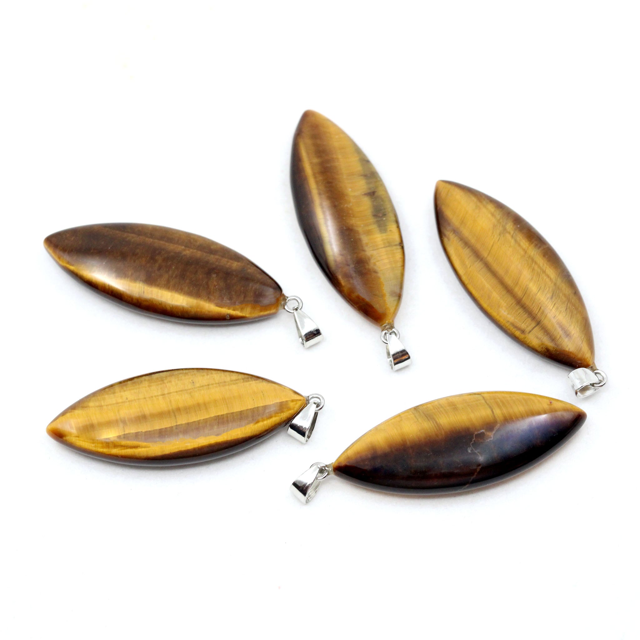 Five surfboard shaped pendants made from Yellow Tiger Eye on a white background.